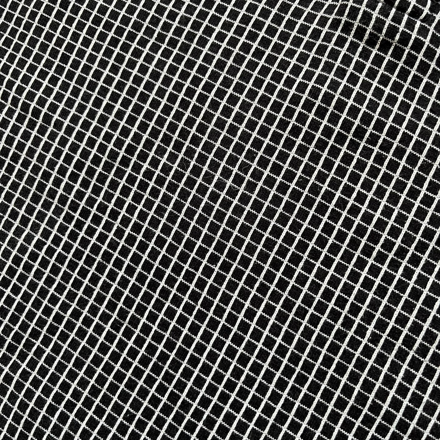 Cartoon Network Scooby-Doo 1999 Golf Polo is a black polo shirt featuring a grid pattern of thin white lines forming small squares across the fabric. The left chest displays an embroidered graphic of Scooby-Doo in a golf outfit digging in sand. The neck tag includes Warner Bros. and Cartoon Network 1999 licensing.