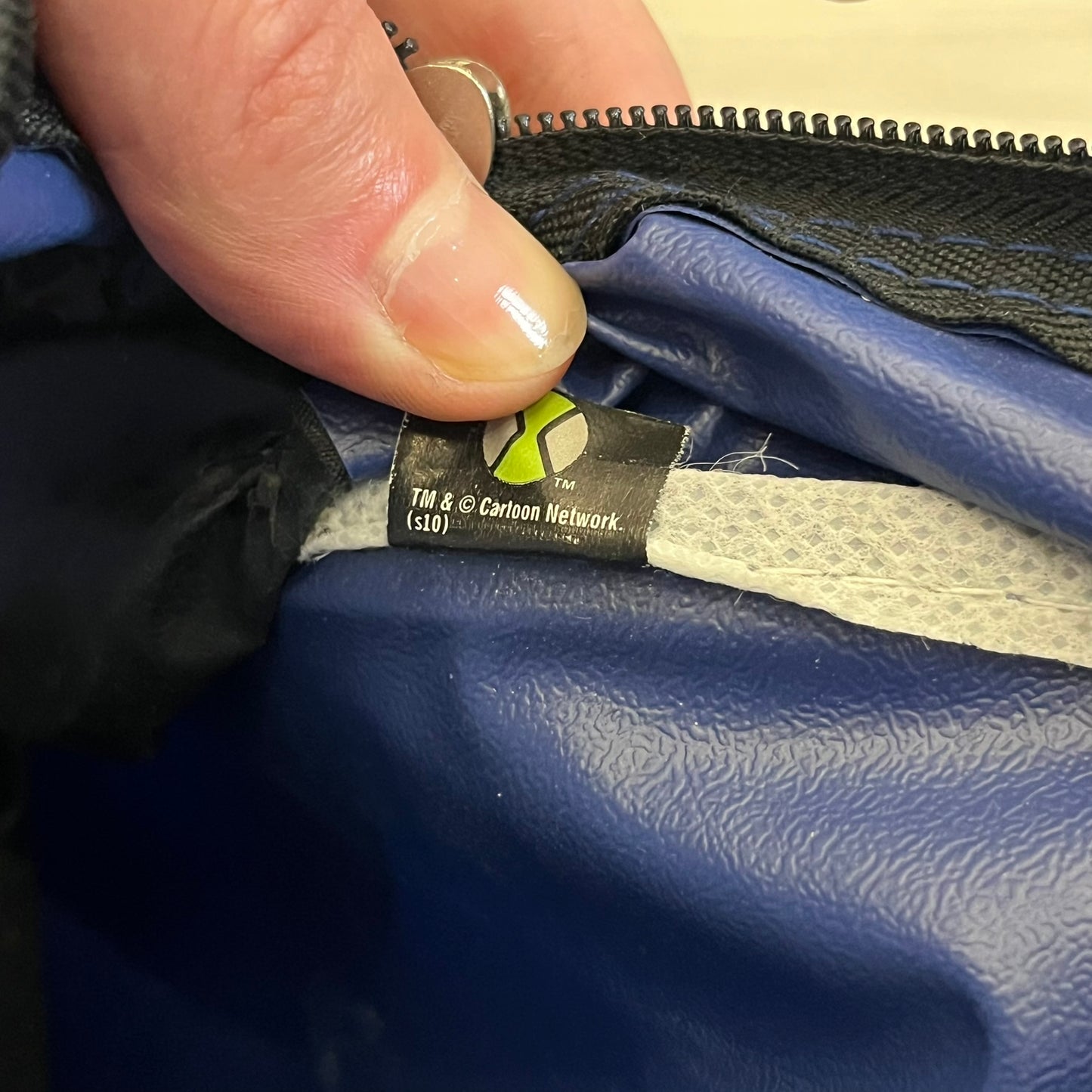 Blue Cartoon Network “Ben 10” handbag with black straps. Features a front graphic of Ben 10 with several of his evolve forms and the Ben 10 logo on the bottom right. Includes an internal Cartoon Network tag marked S10 for the 2010 season.