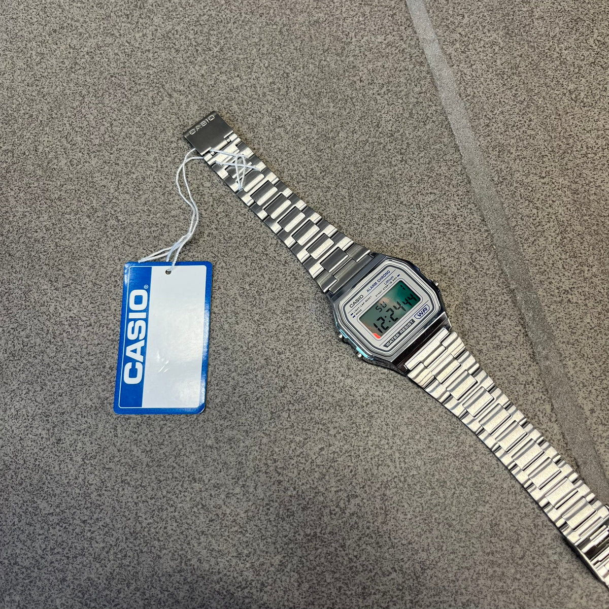 Custom Casio A158 "Chrome" Silver Digital Watch (A158WEA-7EF) is a custom Casio digital watch with a reflective silver filter over the square resin glass screen and a stainless steel band with an adjustable clasp, compatible with wrist sizes from 150 to 205 mm. It has a 1/100-second stopwatch, a daily alarm, an hourly time signal, an auto-calendar, a 12/24-hour format, a green LED light, and water resistance.