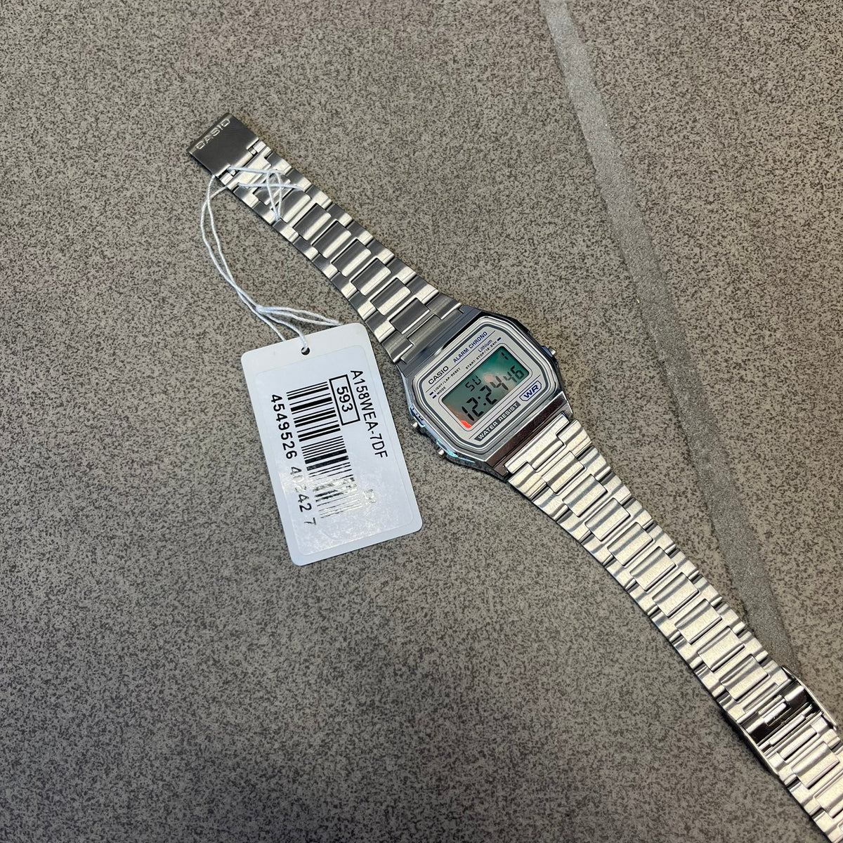Custom Casio A158 "Chrome" Silver Digital Watch (A158WEA-7EF) is a custom Casio digital watch with a reflective silver filter over the square resin glass screen and a stainless steel band with an adjustable clasp, compatible with wrist sizes from 150 to 205 mm. It has a 1/100-second stopwatch, a daily alarm, an hourly time signal, an auto-calendar, a 12/24-hour format, a green LED light, and water resistance.