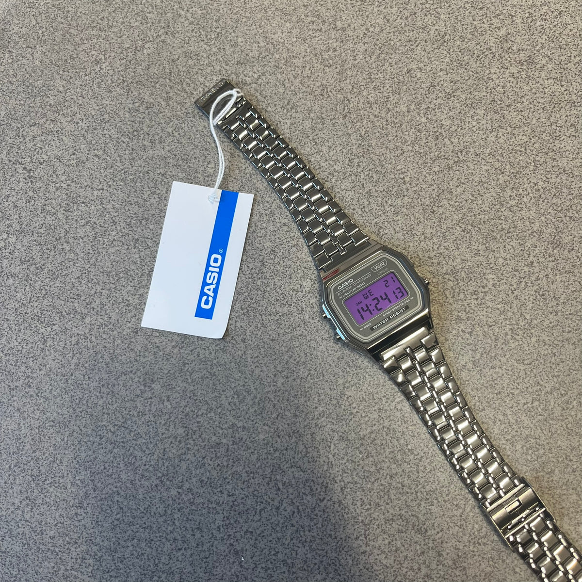 Custom Casio A158 "Royal Purple" Black &amp; Purple Digital Watch is a watch with a purple filter over the square screen and a grey ion-plated stainless steel band with an adjustable clasp. The case comes with a resin glass and a resin and black chrome-plated case and bezel. It has a 1/100-second stopwatch, a daily alarm, an hourly time signal, an auto-calendar, a 12/24-hour format, a green LED light, and water resistance.