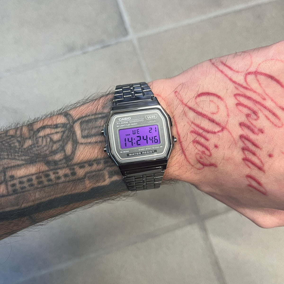 Custom Casio A158 "Royal Purple" Black &amp; Purple Digital Watch is a watch with a purple filter over the square screen and a grey ion-plated stainless steel band with an adjustable clasp. The case comes with a resin glass and a resin and black chrome-plated case and bezel. It has a 1/100-second stopwatch, a daily alarm, an hourly time signal, an auto-calendar, a 12/24-hour format, a green LED light, and water resistance.