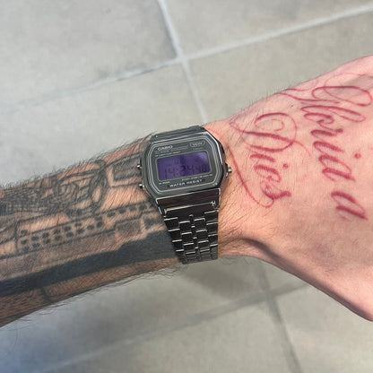 Custom Casio A158 "Royal Purple" Black &amp; Purple Digital Watch is a watch with a purple filter over the square screen and a grey ion-plated stainless steel band with an adjustable clasp. The case comes with a resin glass and a resin and black chrome-plated case and bezel. It has a 1/100-second stopwatch, a daily alarm, an hourly time signal, an auto-calendar, a 12/24-hour format, a green LED light, and water resistance.