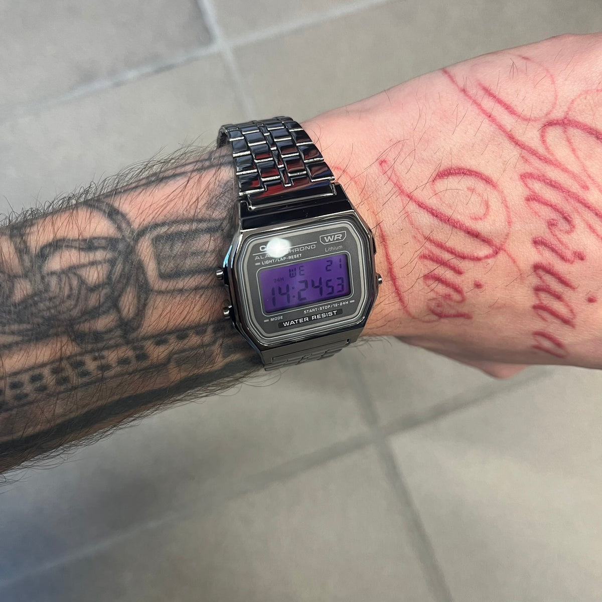 Custom Casio A158 "Royal Purple" Black &amp; Purple Digital Watch is a watch with a purple filter over the square screen and a grey ion-plated stainless steel band with an adjustable clasp. The case comes with a resin glass and a resin and black chrome-plated case and bezel. It has a 1/100-second stopwatch, a daily alarm, an hourly time signal, an auto-calendar, a 12/24-hour format, a green LED light, and water resistance.
