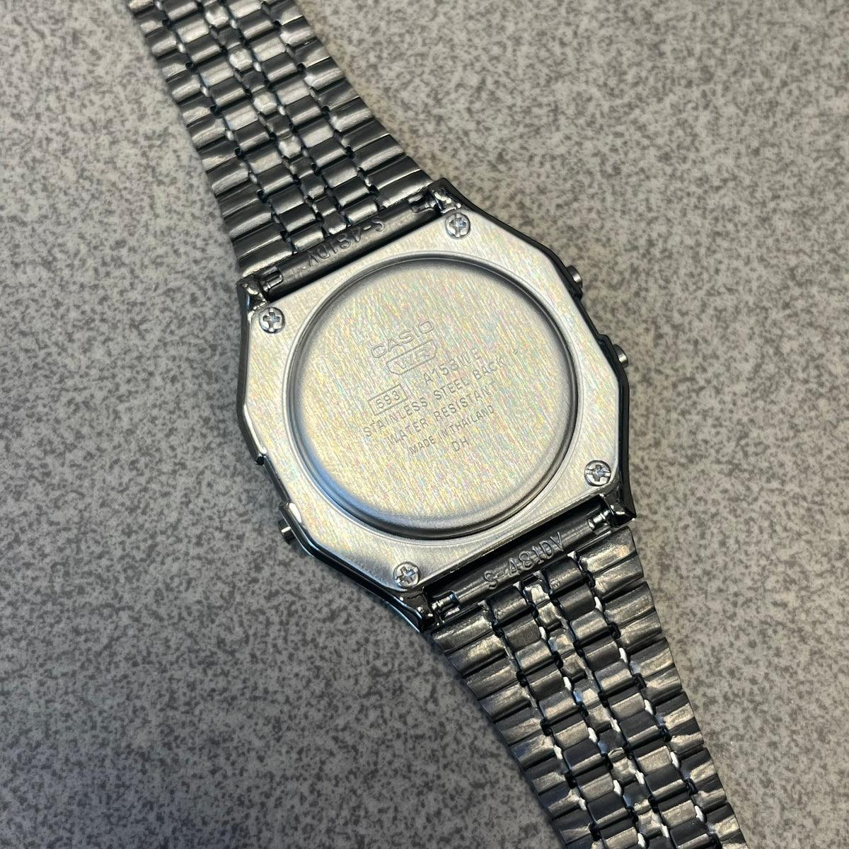 Custom Casio A158 "Royal Purple" Black &amp; Purple Digital Watch is a watch with a purple filter over the square screen and a grey ion-plated stainless steel band with an adjustable clasp. The case comes with a resin glass and a resin and black chrome-plated case and bezel. It has a 1/100-second stopwatch, a daily alarm, an hourly time signal, an auto-calendar, a 12/24-hour format, a green LED light, and water resistance.