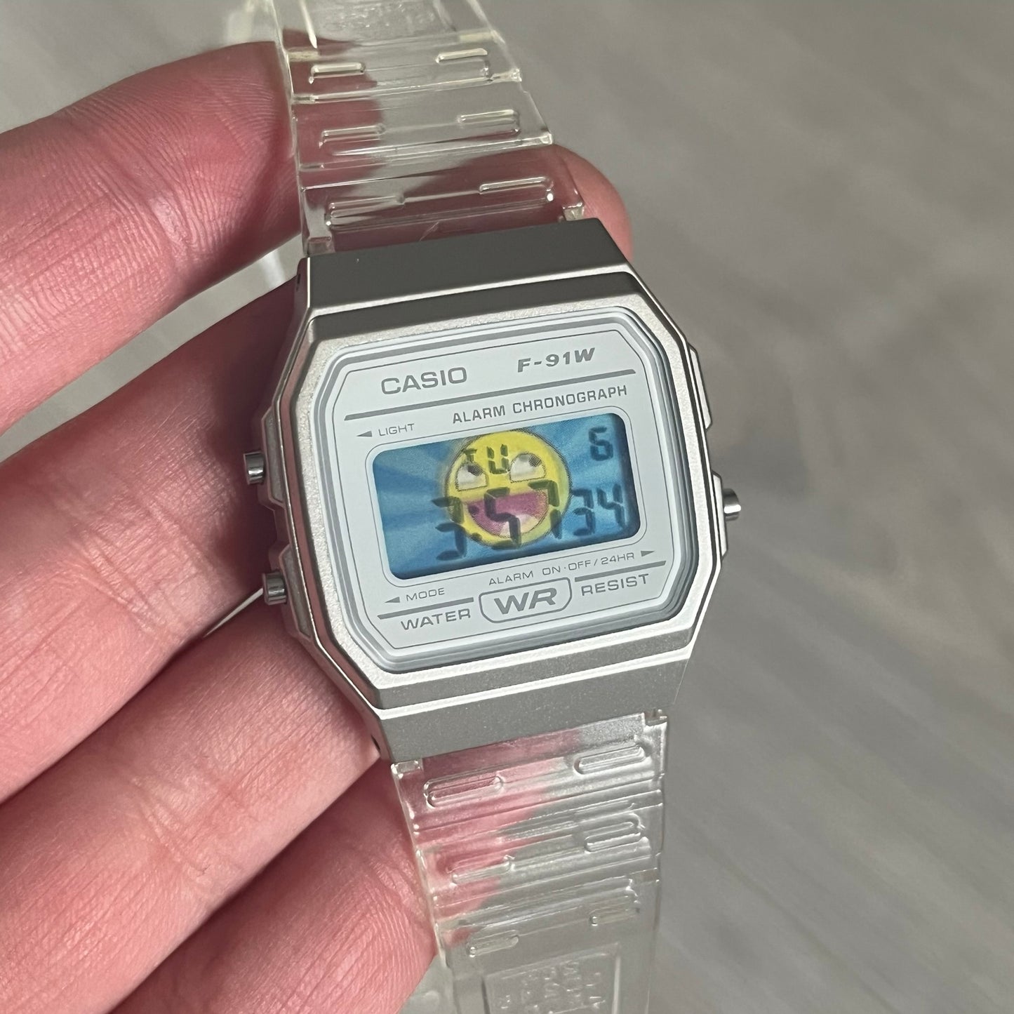 Custom Casio F-91W Clear/Transparent digital watch featuring a Awesome Face filter screen. Slim 8.5 mm profile, lightweight 21 g build and flexible bio-based resin band ensure lasting comfort. Includes alarm, stopwatch, and microlight function for everyday functionality.
