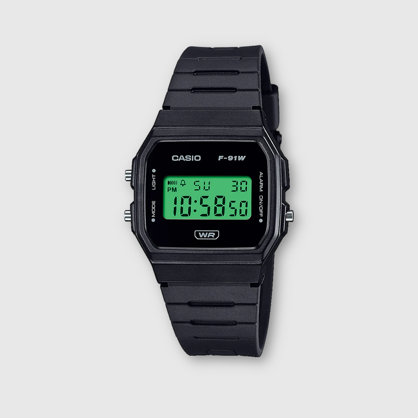 Black Casio digital watch with green display on a light gray background