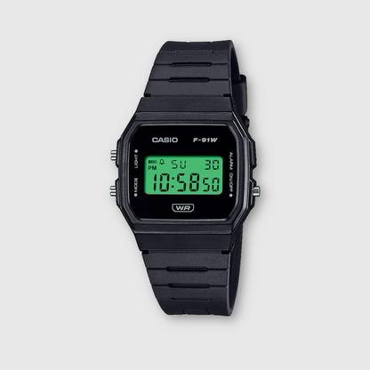 Black Casio digital watch with green display on a light gray background