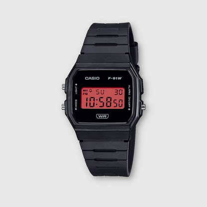 Black Casio digital watch with red display on a light gray background
