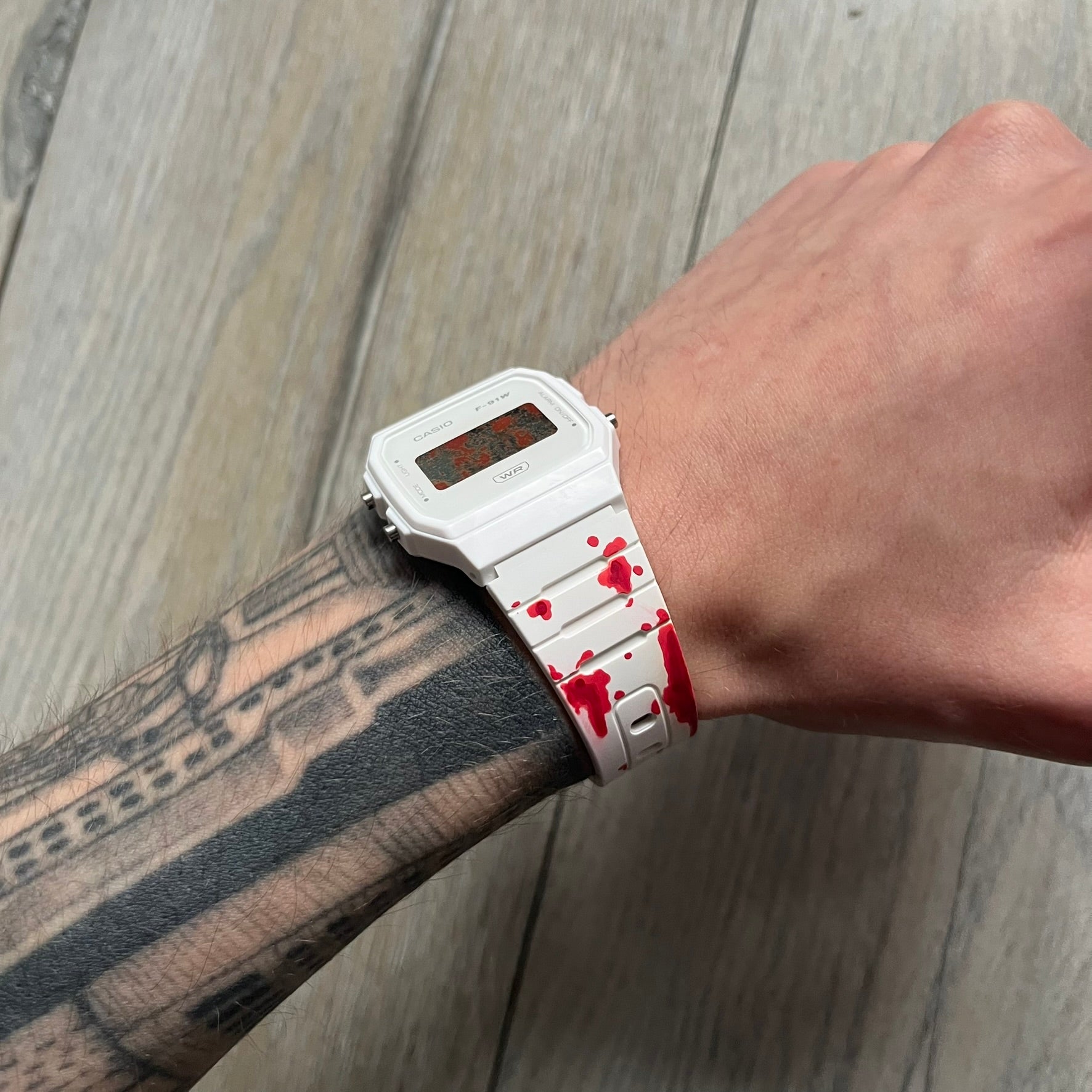 Custom Casio F-91W White digital watch featuring a Bloody filter screen and custom painted straps. Slim 8.5 mm profile, lightweight 21 g build and flexible bio-based resin band ensure lasting comfort. Includes alarm, stopwatch, and microlight function for everyday functionality.

This watch is a 1/1 sample. The paint on the straps is not holding perfectly as with more force it can be smudged. For the best effect we reccomend covering it with a special paint or spray to make it 100% last.&nbsp;