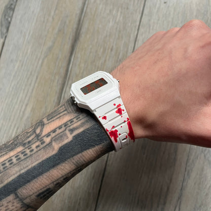 Custom Casio F-91W White digital watch featuring a Bloody filter screen and custom painted straps. Slim 8.5 mm profile, lightweight 21 g build and flexible bio-based resin band ensure lasting comfort. Includes alarm, stopwatch, and microlight function for everyday functionality.

This watch is a 1/1 sample. The paint on the straps is not holding perfectly as with more force it can be smudged. For the best effect we reccomend covering it with a special paint or spray to make it 100% last.&nbsp;