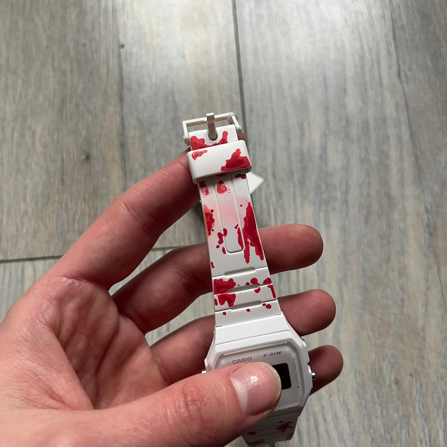 Custom Casio F-91W White digital watch featuring a Bloody filter screen and custom painted straps. Slim 8.5 mm profile, lightweight 21 g build and flexible bio-based resin band ensure lasting comfort. Includes alarm, stopwatch, and microlight function for everyday functionality.

This watch is a 1/1 sample. The paint on the straps is not holding perfectly as with more force it can be smudged. For the best effect we reccomend covering it with a special paint or spray to make it 100% last.&nbsp;