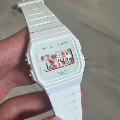 Custom Casio F-91W White digital watch featuring a Bloody filter screen. Slim 8.5 mm profile, lightweight 21 g build and flexible bio-based resin band ensure lasting comfort. Includes alarm, stopwatch, and microlight function for everyday functionality.