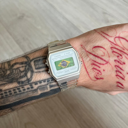 Custom Casio F-91W Clear/Transparent digital watch featuring a Brazil Flag filter screen. Slim 8.5 mm profile, lightweight 21 g build and flexible bio-based resin band ensure lasting comfort. Includes alarm, stopwatch, and microlight function for everyday functionality.