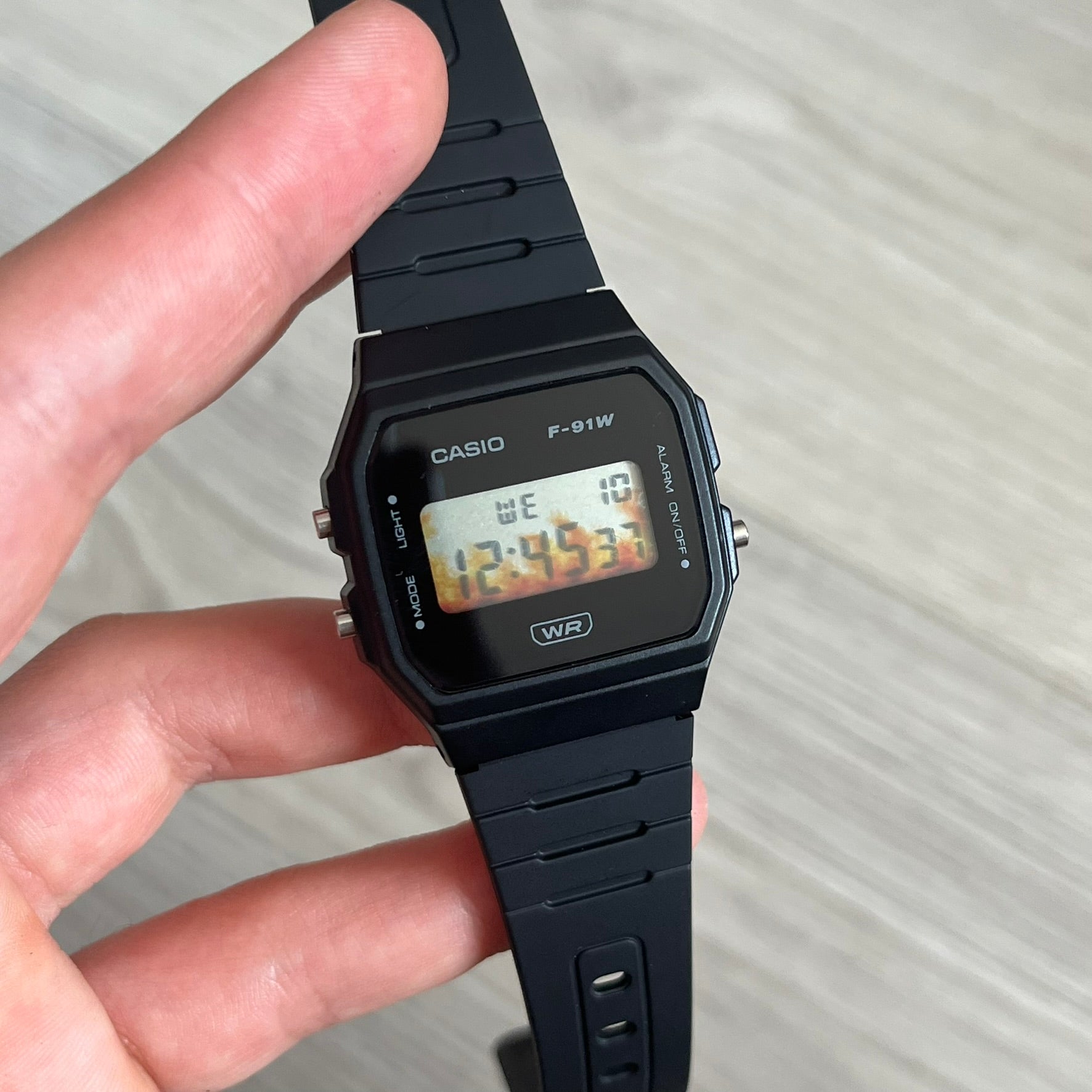 Custom Casio F-91W Black digital watch featuring a Flame filter screen. Slim 8.5 mm profile, lightweight 21 g build and flexible bio-based resin band ensure lasting comfort. Includes alarm, stopwatch, and microlight function for everyday functionality.