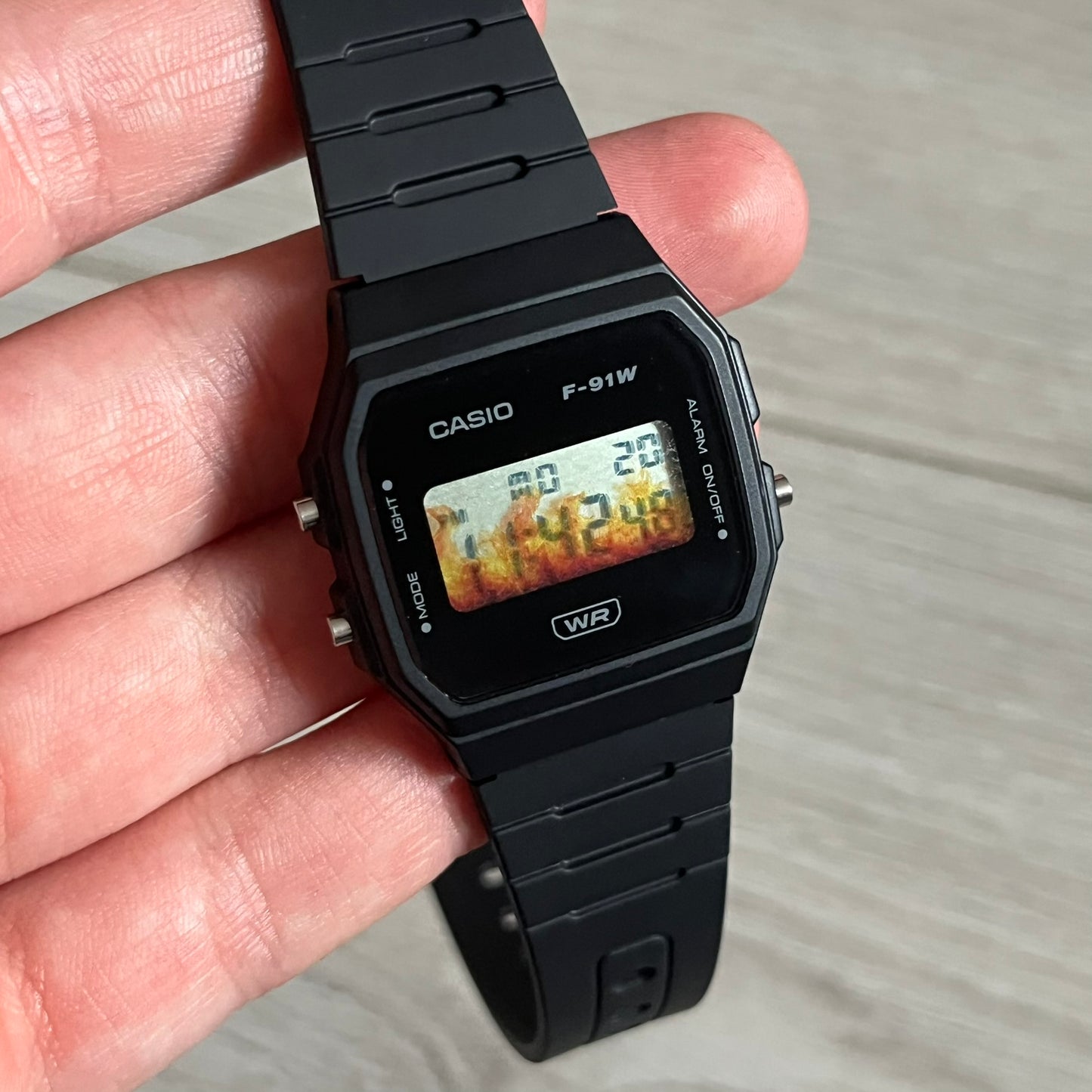 Custom Casio F-91W Black digital watch featuring a Flame filter screen. Slim 8.5 mm profile, lightweight 21 g build and flexible bio-based resin band ensure lasting comfort. Includes alarm, stopwatch, and microlight function for everyday functionality.