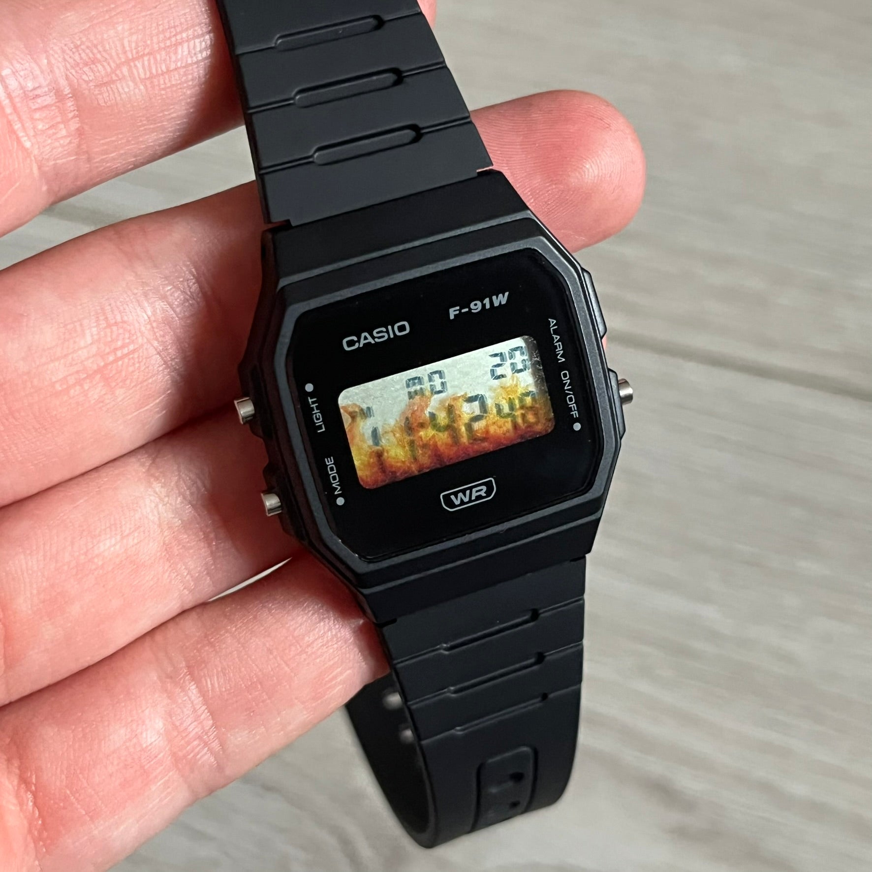 Custom Casio F-91W Black digital watch featuring a Flame filter screen. Slim 8.5 mm profile, lightweight 21 g build and flexible bio-based resin band ensure lasting comfort. Includes alarm, stopwatch, and microlight function for everyday functionality.