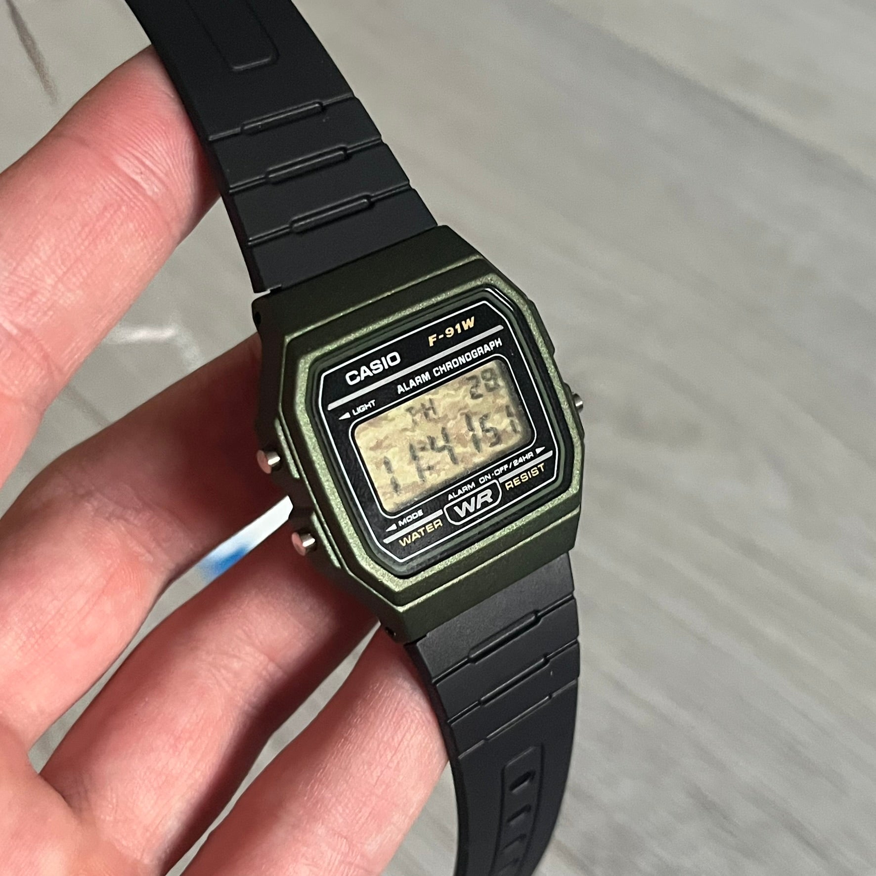 Custom Casio F-91W Military Green digital watch featuring a Camo filter screen. Slim 8.5 mm profile, lightweight 21 g build and flexible bio-based resin band ensure lasting comfort. Includes alarm, stopwatch, and microlight function for everyday functionality.