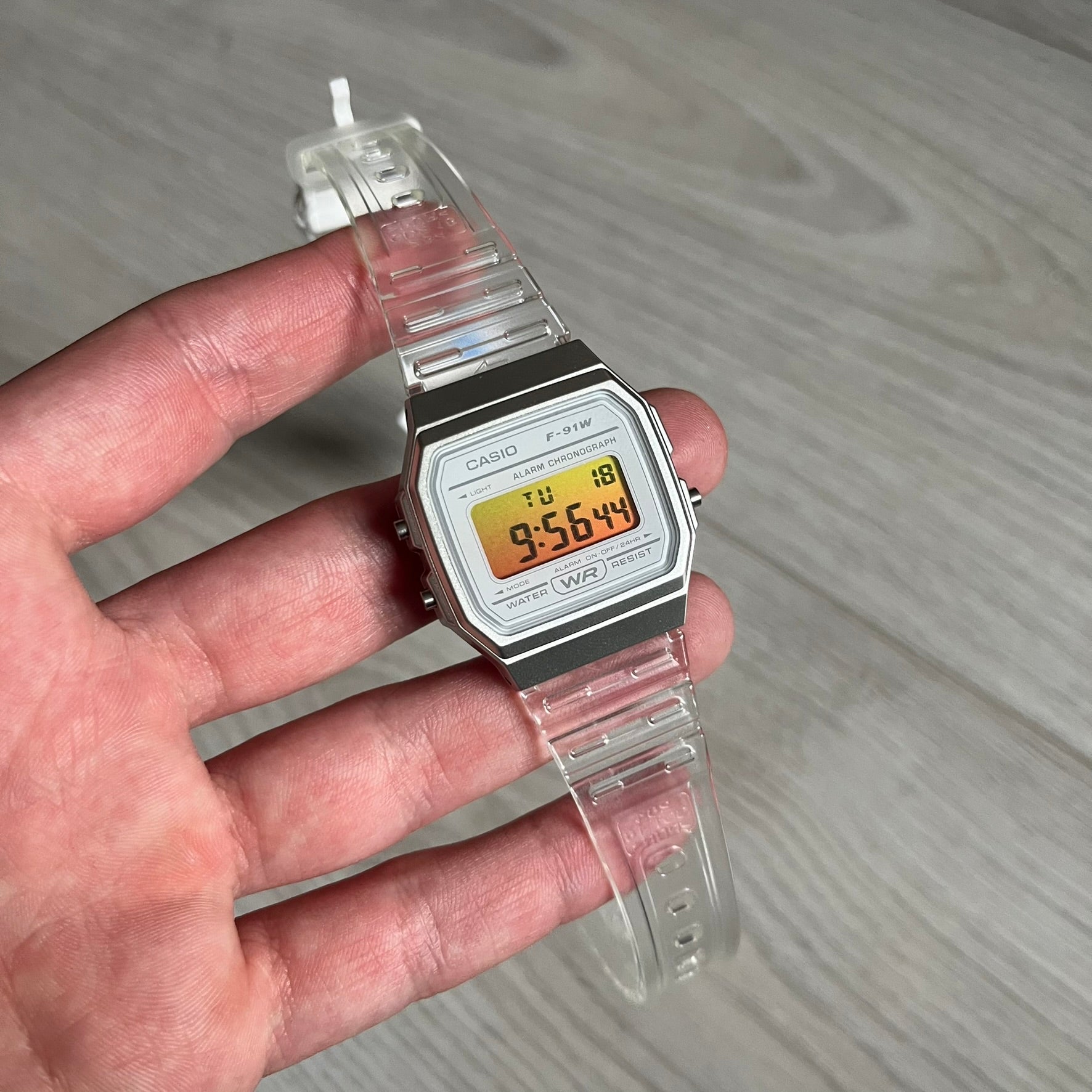 Custom Casio F-91W Clear/Transparent digital watch featuring a Yellow gradient. Slim 8.5 mm profile, lightweight 21 g build and flexible bio-based resin band ensure lasting comfort. Includes alarm, stopwatch, and microlight function for everyday functionality.