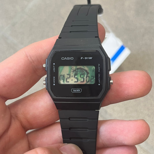 Custom Casio F-91W Black digital watch featuring a Anime green eyes filter screen. Slim 8.5 mm profile, lightweight 21 g build and flexible bio-based resin band ensure lasting comfort. Includes alarm, stopwatch, and microlight function for everyday functionality.
