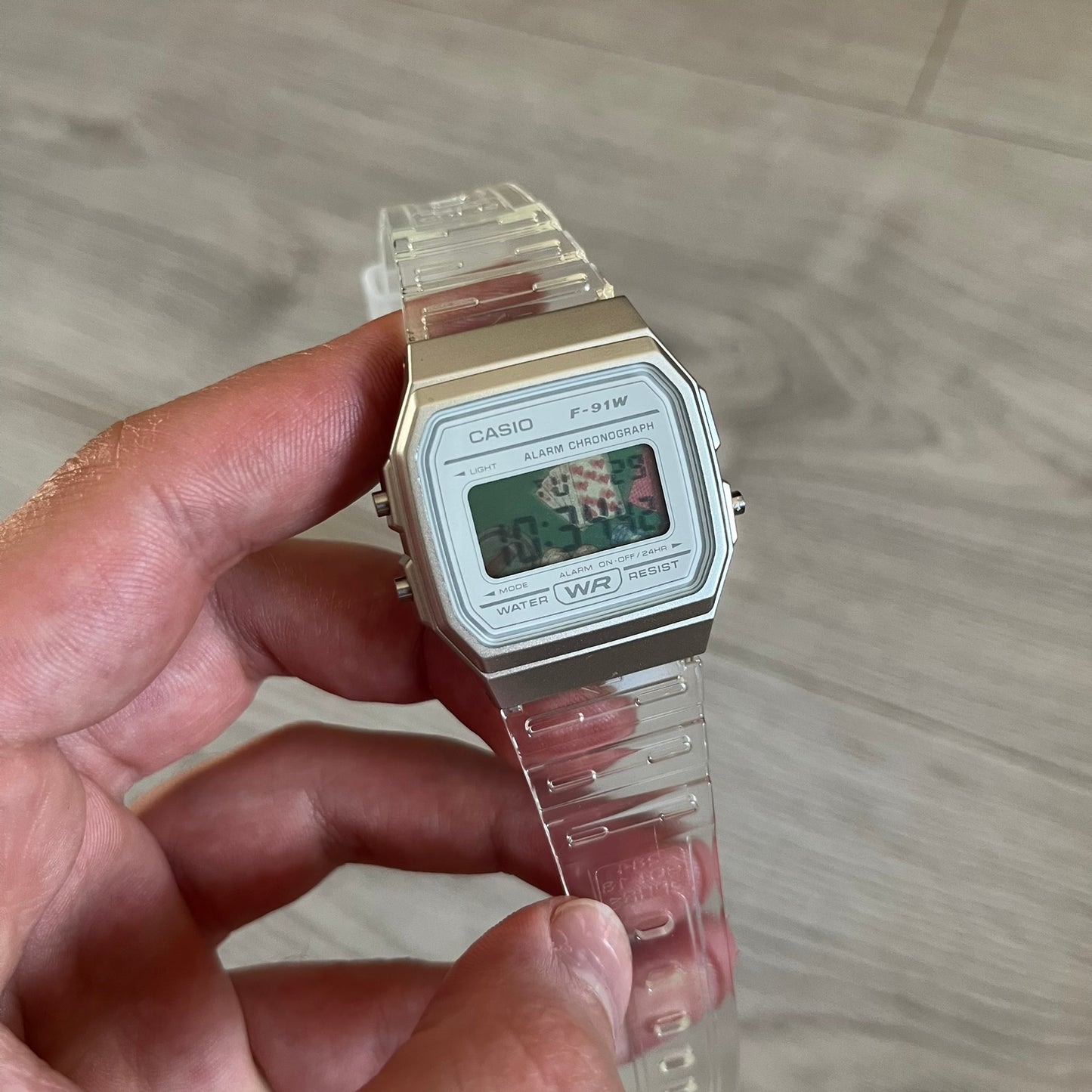 Custom Casio F-91W Clear/Transparent digital watch featuring a Poker table graphic filter screen. Slim 8.5 mm profile, lightweight 21 g build and flexible bio-based resin band ensure lasting comfort. Includes alarm, stopwatch, and microlight function for everyday functionality.