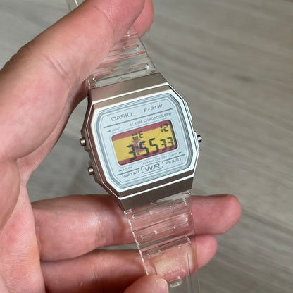 Custom Casio F-91W Clear/Transparent digital watch featuring a Spanish Flag filter screen. Slim 8.5 mm profile, lightweight 21 g build and flexible bio-based resin band ensure lasting comfort. Includes alarm, stopwatch, and microlight function for everyday functionality.