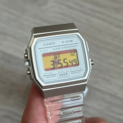 Custom Casio F-91W Clear/Transparent digital watch featuring a Spanish Flag filter screen. Slim 8.5 mm profile, lightweight 21 g build and flexible bio-based resin band ensure lasting comfort. Includes alarm, stopwatch, and microlight function for everyday functionality.