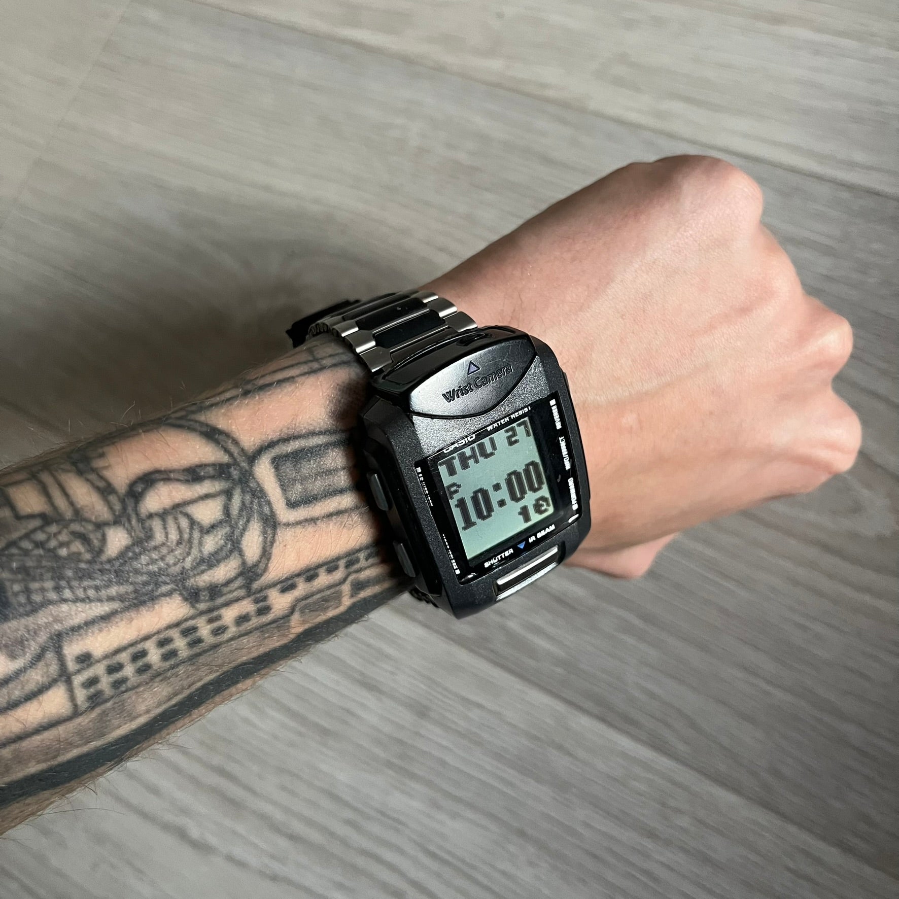 Casio Wrist Camera 2220 WQV-1 Digital Watch from the 2000s, made in Japan. Features a built-in camera module at the top, with six function buttons for photo capture, IR communication, alarm, timer, stopwatch, and gallery viewing. Monochrome photo output in shades of black, white, and gray; fitted with a non-original bracelet.