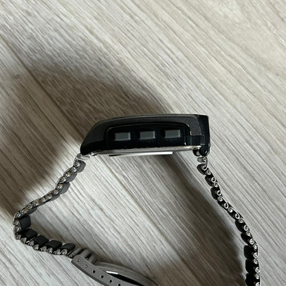 Casio Wrist Camera 2220 WQV-1 Digital Watch from the 2000s, made in Japan. Features a built-in camera module at the top, with six function buttons for photo capture, IR communication, alarm, timer, stopwatch, and gallery viewing. Monochrome photo output in shades of black, white, and gray; fitted with a non-original bracelet.