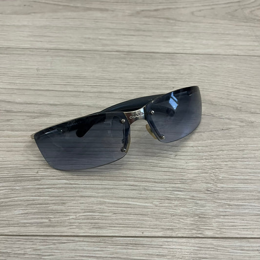 Chanel 4008 Rimless Silver Sunglasses with blue gradient lenses, combining a futuristic rimless design with vintage early 2000s style. Features CC logos on the temples, Chanel engraving on the bridge, and a silver metal frame. Made in Italy with CE certification.
