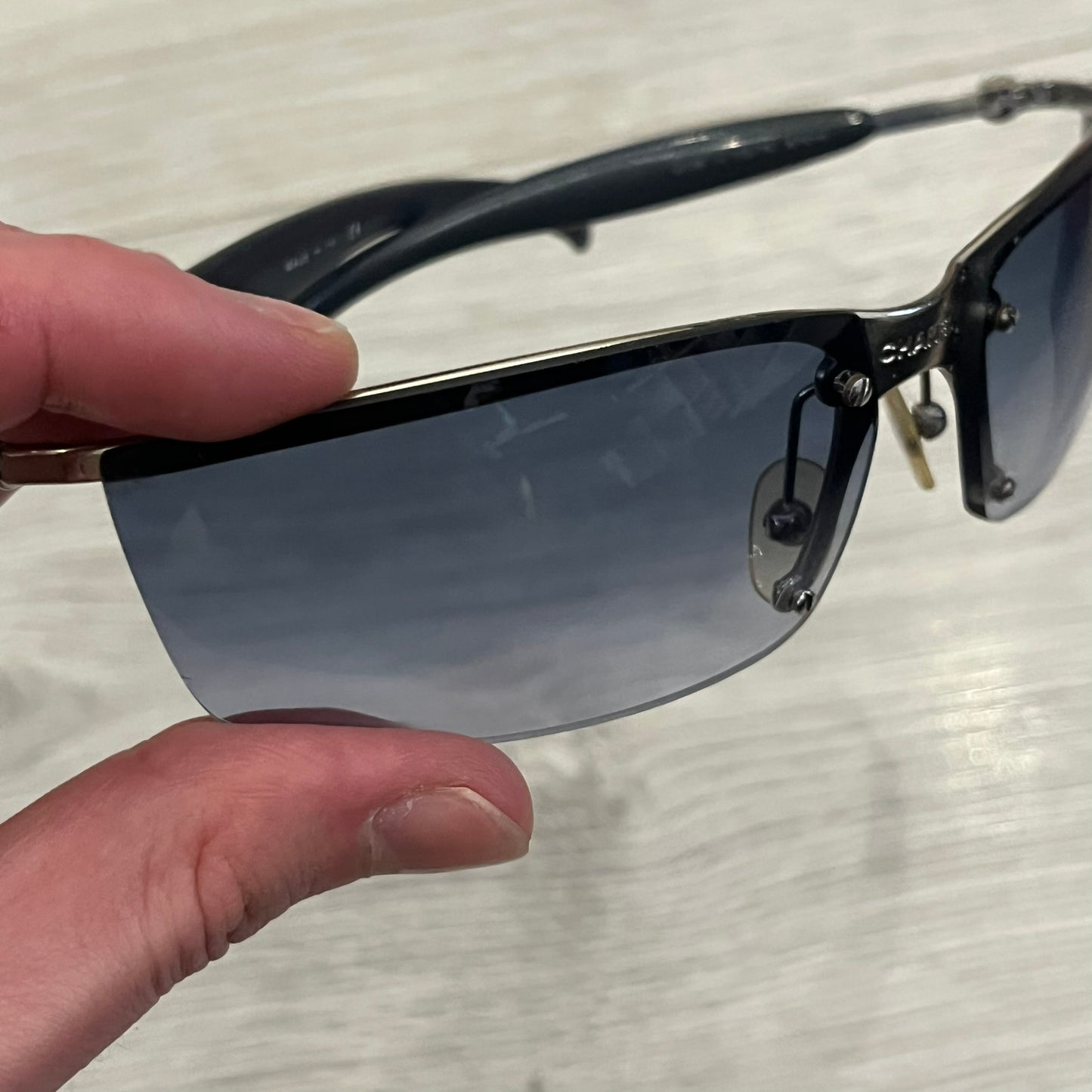 Chanel 4008 Rimless Silver Sunglasses with blue gradient lenses, combining a futuristic rimless design with vintage early 2000s style. Features CC logos on the temples, Chanel engraving on the bridge, and a silver metal frame. Made in Italy with CE certification.
