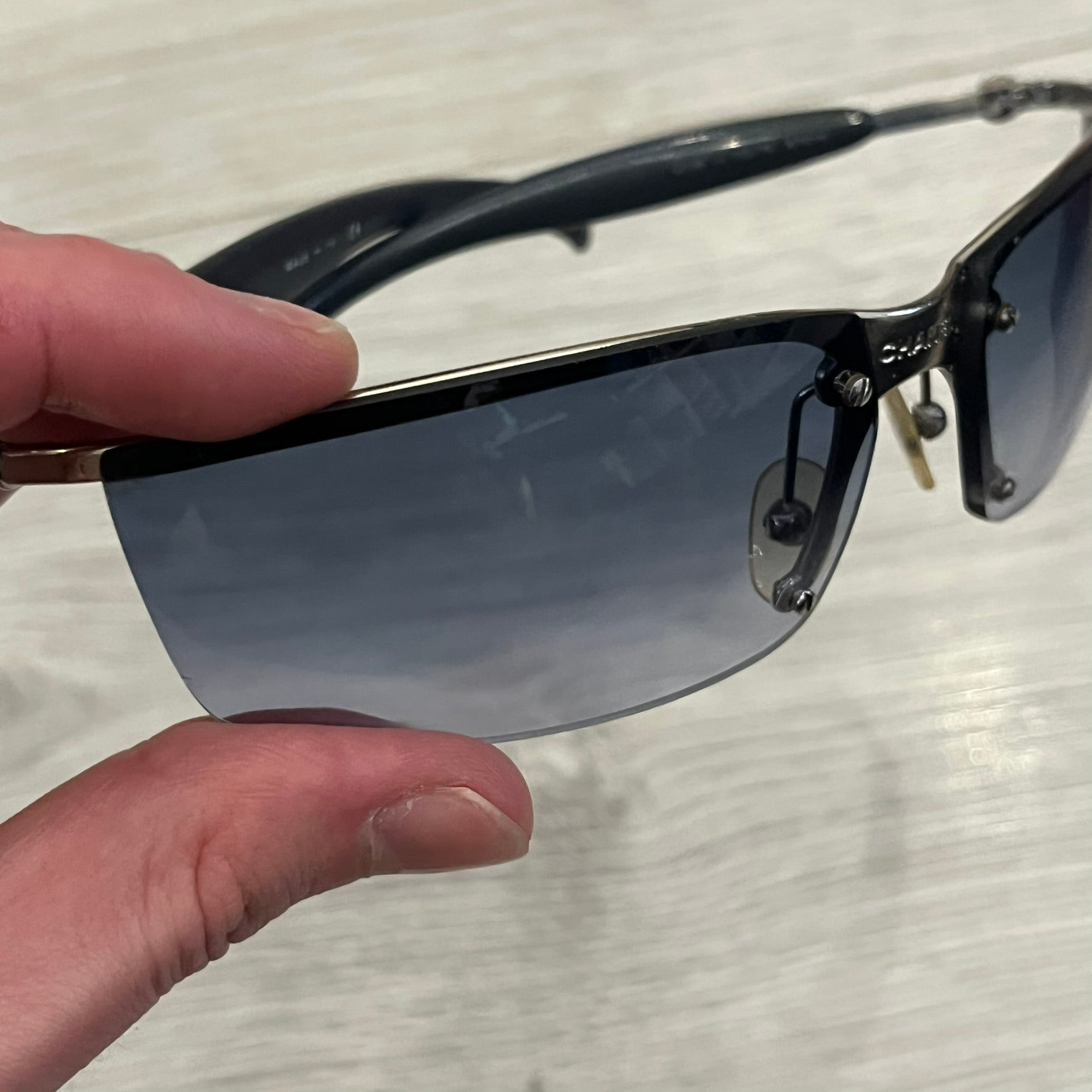 Chanel 4008 Rimless Silver Sunglasses with blue gradient lenses, combining a futuristic rimless design with vintage early 2000s style. Features CC logos on the temples, Chanel engraving on the bridge, and a silver metal frame. Made in Italy with CE certification.
