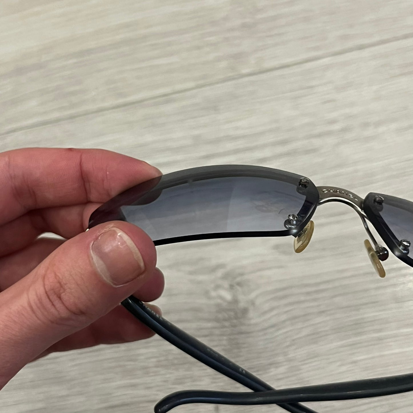 Chanel 4008 Rimless Silver Sunglasses with blue gradient lenses, combining a futuristic rimless design with vintage early 2000s style. Features CC logos on the temples, Chanel engraving on the bridge, and a silver metal frame. Made in Italy with CE certification.
