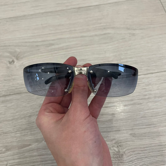 Chanel 4008 Rimless Silver Sunglasses with blue gradient lenses, combining a futuristic rimless design with vintage early 2000s style. Features CC logos on the temples, Chanel engraving on the bridge, and a silver metal frame. Made in Italy with CE certification.
