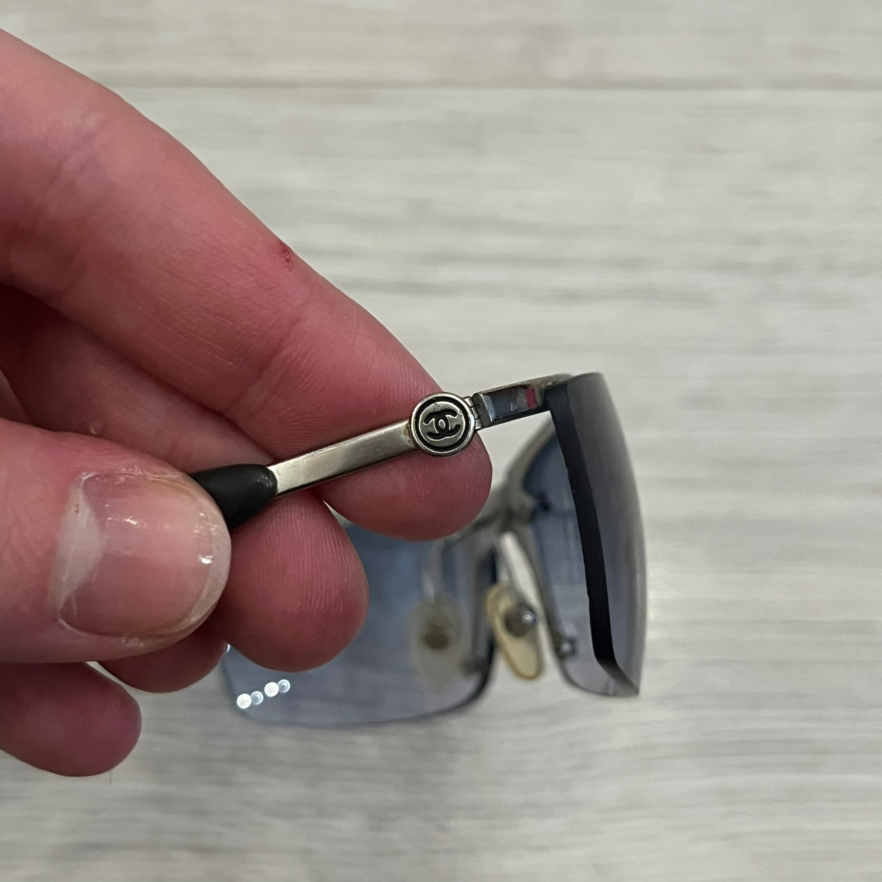 Chanel 4008 Rimless Silver Sunglasses with blue gradient lenses, combining a futuristic rimless design with vintage early 2000s style. Features CC logos on the temples, Chanel engraving on the bridge, and a silver metal frame. Made in Italy with CE certification.
