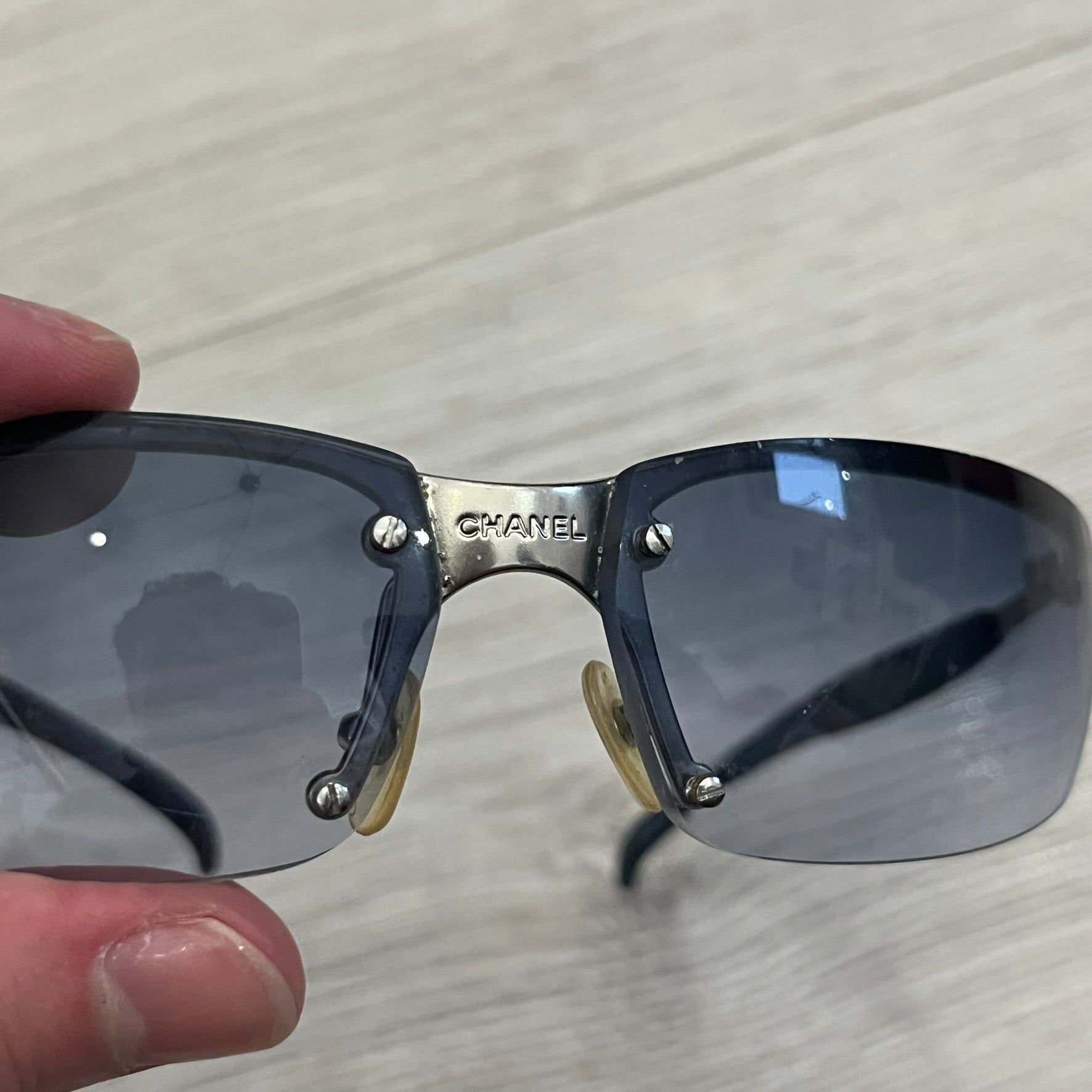 Chanel 4008 Rimless Silver Sunglasses with blue gradient lenses, combining a futuristic rimless design with vintage early 2000s style. Features CC logos on the temples, Chanel engraving on the bridge, and a silver metal frame. Made in Italy with CE certification.

