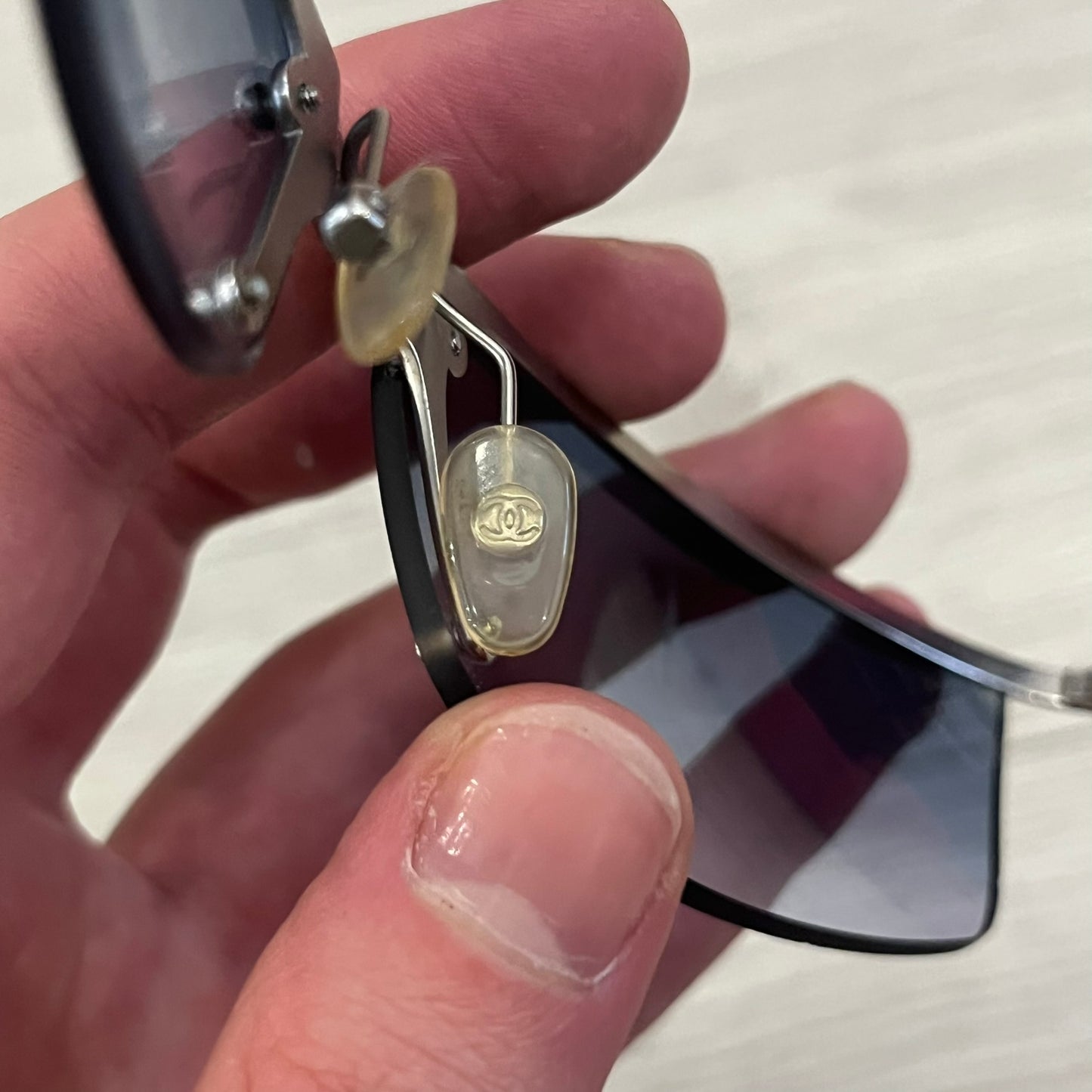 Chanel 4008 Rimless Silver Sunglasses with blue gradient lenses, combining a futuristic rimless design with vintage early 2000s style. Features CC logos on the temples, Chanel engraving on the bridge, and a silver metal frame. Made in Italy with CE certification.
