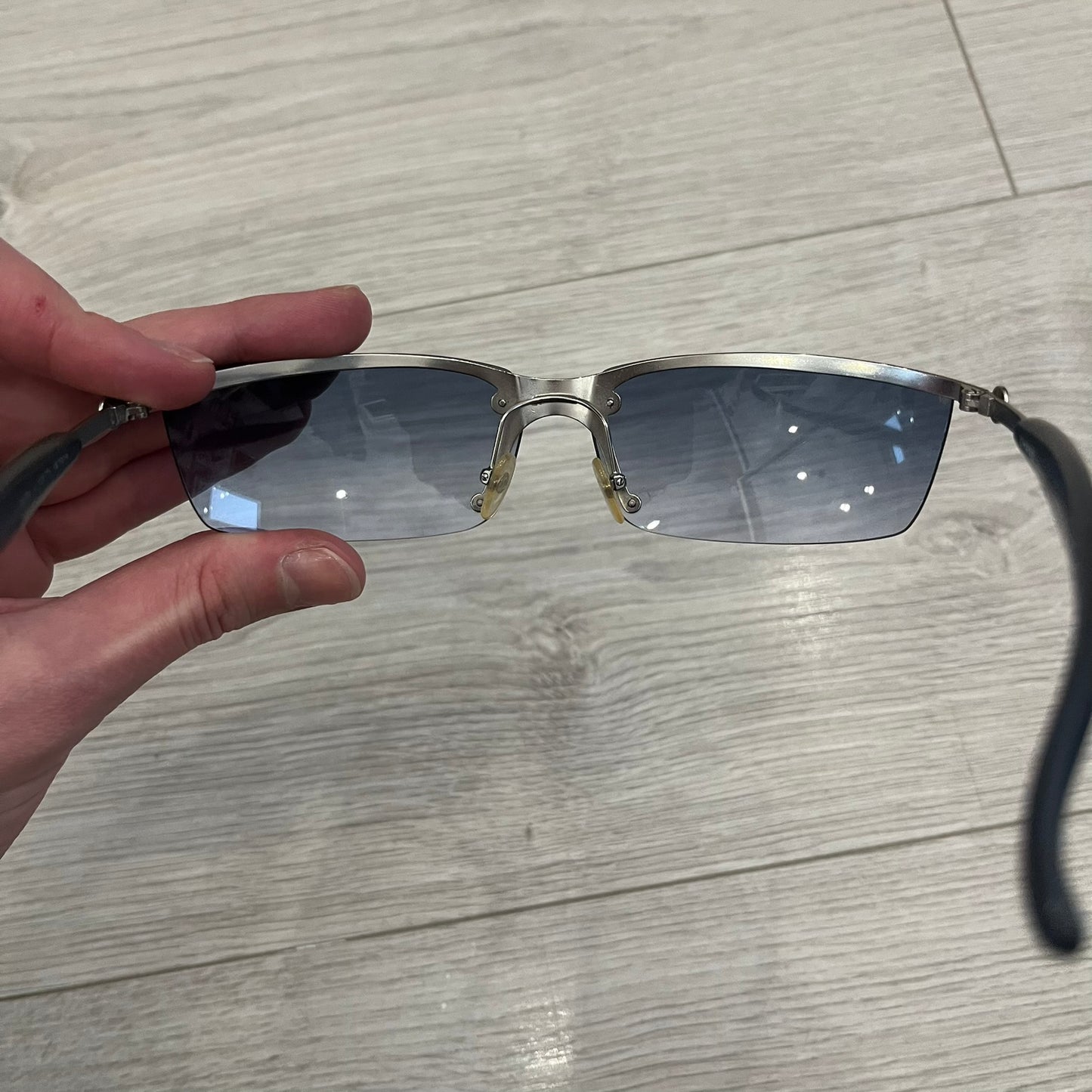 Chanel 4008 Rimless Silver Sunglasses with blue gradient lenses, combining a futuristic rimless design with vintage early 2000s style. Features CC logos on the temples, Chanel engraving on the bridge, and a silver metal frame. Made in Italy with CE certification.
