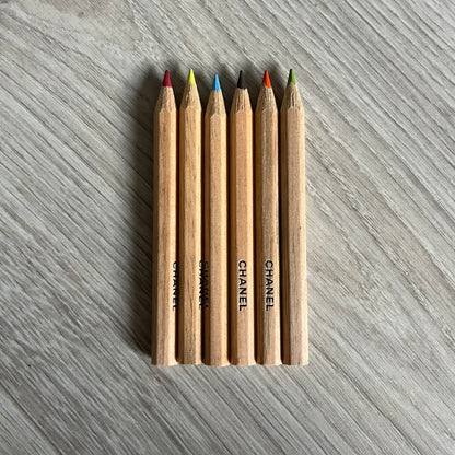 Chanel Mother’s Day Colored Pencils Set from 2021, presented in a white cylindrical tube with “Happy Mother’s Day” text and the Chanel logo on top. A Chanel Beauté complimentary gift featuring six branded colored pencils in blue, red, yellow, brown, orange, and green.