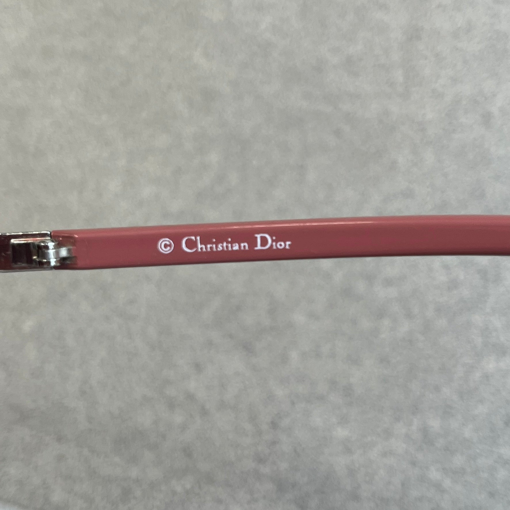 Christian Dior Viktim 2 Pink Sunglasses are an early 2000's eyewear piece from the Safilo era, featuring a futuristic rimless shield silhouette with a sleek wraparound lens design. The sunglasses have a pink/rose tinted lens with subtle Dior logo details at the bottom and minimalist framing. Made in Austria, they come complete with a silver Dior case.