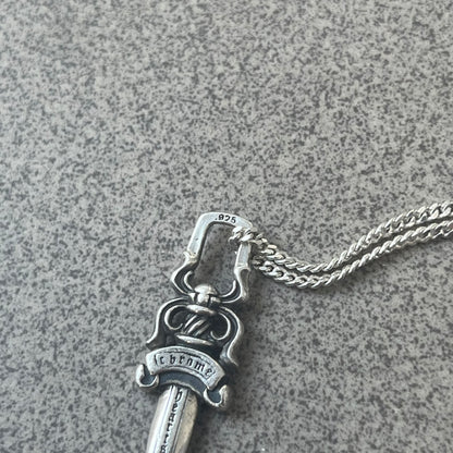Chrome Hearts Dagger Zipper Pendant crafted from .925 silver, featuring the brand’s signature double-sided dagger design with “Chrome” on the guard and “Hearts” on the blade. Comes on a standard 925 Silver chain (non-CH). Square bail for chain attachment with 925 tag on one side and 89 03 on the other. The dagger was originally a zipper pull.