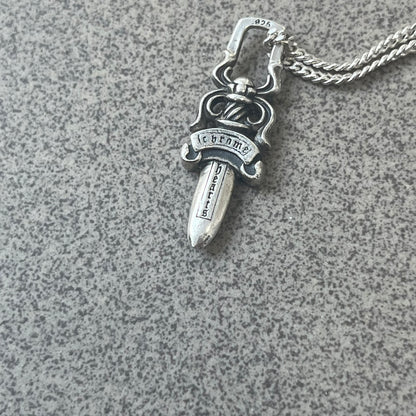 Chrome Hearts Dagger Zipper Pendant crafted from .925 silver, featuring the brand’s signature double-sided dagger design with “Chrome” on the guard and “Hearts” on the blade. Comes on a standard 925 Silver chain (non-CH). Square bail for chain attachment with 925 tag on one side and 89 03 on the other. The dagger was originally a zipper pull.