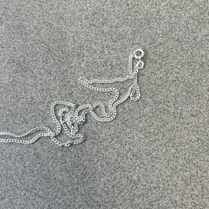 Chrome Hearts Dagger Zipper Pendant crafted from .925 silver, featuring the brand’s signature double-sided dagger design with “Chrome” on the guard and “Hearts” on the blade. Comes on a standard 925 Silver chain (non-CH). Square bail for chain attachment with 925 tag on one side and 89 03 on the other. The dagger was originally a zipper pull.