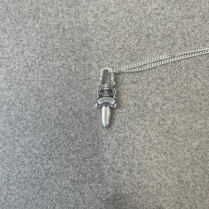 Chrome Hearts Dagger Zipper Pendant crafted from .925 silver, featuring the brand’s signature double-sided dagger design with “Chrome” on the guard and “Hearts” on the blade. Comes on a standard 925 Silver chain (non-CH). Square bail for chain attachment with 925 tag on one side and 89 03 on the other. The dagger was originally a zipper pull.