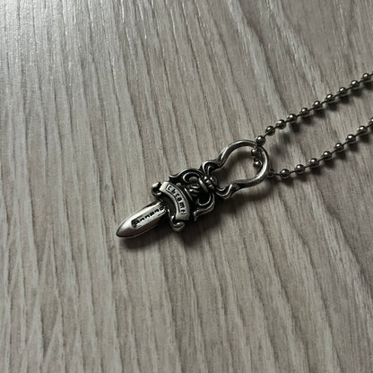 Chrome Hearts Dagger Zipper Pendant crafted from .925 silver, featuring the brand’s signature double-sided dagger design with “Chrome” on the guard and “Hearts” on the blade. Comes on a standard steel ball chain (non-CH). Circular bail for chain attachment. The dagger was originally a zipper pull.