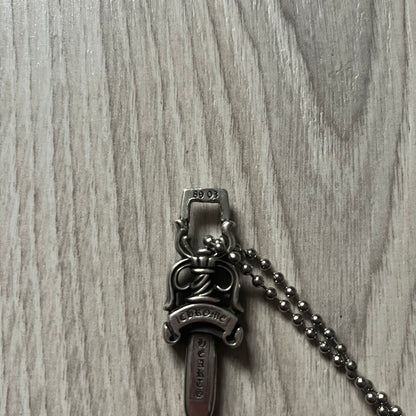 Chrome Hearts Dagger #10 Pendant crafted from genuine .925 silver, featuring the brand’s signature double-sided dagger design with “Chrome” on the guard and “Hearts” on the blade. Comes on a standard steel ball chain (non-CH). The top rectangular bail includes engraved markings: “89/03” on one side and “Sterling” on the other.