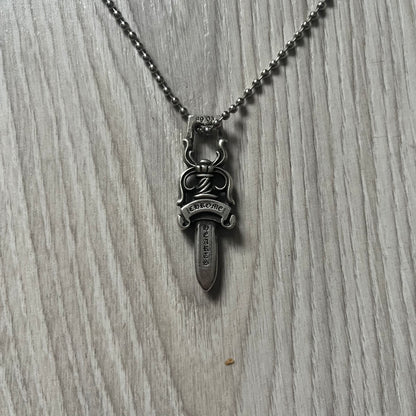 Chrome Hearts Dagger #10 Pendant crafted from genuine .925 silver, featuring the brand’s signature double-sided dagger design with “Chrome” on the guard and “Hearts” on the blade. Comes on a standard steel ball chain (non-CH). The top rectangular bail includes engraved markings: “89/03” on one side and “Sterling” on the other.&nbsp;