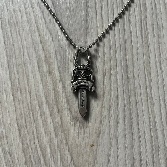 Chrome Hearts Dagger #10 Pendant crafted from genuine .925 silver, featuring the brand’s signature double-sided dagger design with “Chrome” on the guard and “Hearts” on the blade. Comes on a standard steel ball chain (non-CH). The top rectangular bail includes engraved markings: “89/03” on one side and “Sterling” on the other.&nbsp;
