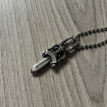 Chrome Hearts Dagger #10 Pendant crafted from genuine .925 silver, featuring the brand’s signature double-sided dagger design with “Chrome” on the guard and “Hearts” on the blade. Comes on a standard steel ball chain (non-CH). The top rectangular bail includes engraved markings: “89/03” on one side and “Sterling” on the other.&nbsp;