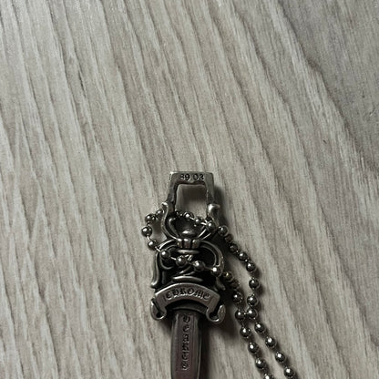 Chrome Hearts Dagger #10 Pendant crafted from genuine .925 silver, featuring the brand’s signature double-sided dagger design with “Chrome” on the guard and “Hearts” on the blade. Comes on a standard steel ball chain (non-CH). The top rectangular bail includes engraved markings: “89/03” on one side and “Sterling” on the other.&nbsp;